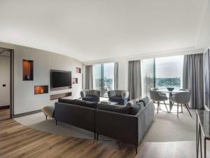 a living room with a couch and a table with chairs at Radisson Blu Waterfront Hotel, Stockholm in Stockholm