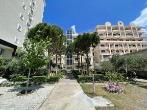 uma passagem em frente a um edifício com árvores em Vila Beni em Shëngjin