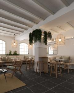 restauracja ze stołami, krzesłami i oknami w obiekcie Calendula Hotel w Sant Feliu de Guixols