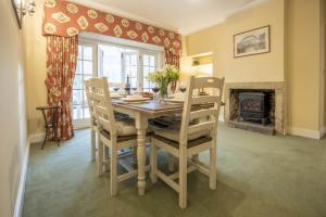 a dining room with a table and chairs and a fireplace at Eslington Lodge in Alnwick