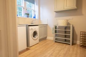 a laundry room with a washing machine and a sink at Eslington Lodge in Alnwick