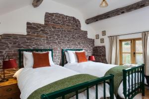 two beds in a room with a stone wall at Stone House in Leominster