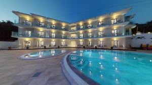 um hotel com piscina em frente a um edifício em Golden Lion Parga em Parga