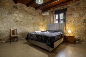 een slaapkamer met een bed in een stenen muur bij Villa dimitris in Kissamos +40 foto's