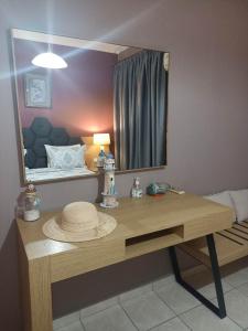 a dressing table with a mirror and a hat on it at Evangelia in Karfas