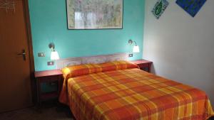 1 dormitorio con 1 cama y 2 mesitas de noche con luces en Locanda le Mandriane, en Albinia