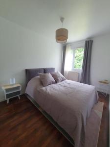 a bedroom with a white bed and a window at Maison à Poitiers - Futuroscope in Poitiers