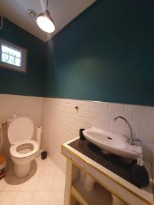 La salle de bains est pourvue de toilettes et d'un lavabo. dans l'établissement Maison à Poitiers - Futuroscope, à Poitiers