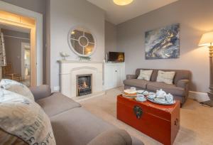 a living room with a couch and a fireplace at Khina Cottage in Kingsgate