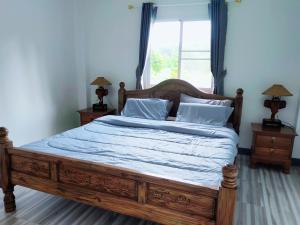 een slaapkamer met een bed met een houten frame en een raam bij Klai house 