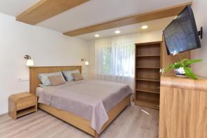 a bedroom with a bed and a flat screen tv at SMILTIS in Palanga