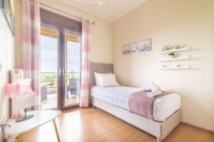 sypialnia z łóżkiem, stołem i oknem w obiekcie Luxury Maisonette near the Beach w mieście Gázion