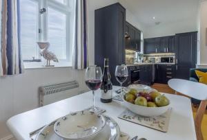 a kitchen with two glasses of wine and a bowl of fruit at The Link in Cromer