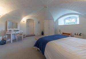 a bedroom with a large white bed and a desk at The Link in Cromer
