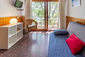 a living room with a couch and a tv at Polcent 3 Pequeño apartamento cercano a la playa in S'Agaro