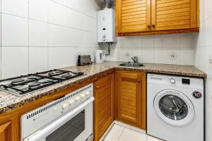 a kitchen with a stove and a washing machine at Polcent 3 Pequeño apartamento cercano a la playa in S'Agaro