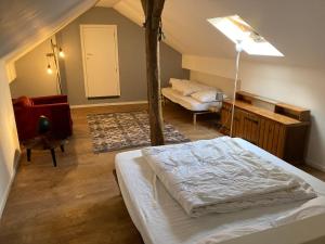 a bedroom with a bed and a room with a couch at Green Escape Durbuy in Durbuy