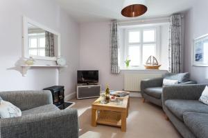 a living room with two couches and a coffee table at Solebay Cottage in Lower Boscaswell