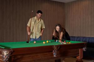un homme et une femme debout à côté d'un billard dans l'établissement Three Corners Sunny Beach Resort, à Hurghada