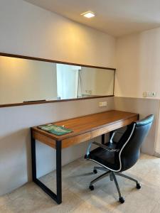 a desk with a mirror and a black chair at MyHabitat - KLCC 2 bedroom in Kuala Lumpur