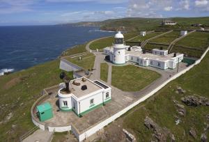 an aerial view of a lighthouse on the coast at Solebay Cottage in Lower Boscaswell