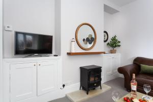 a living room with a tv and a stove at Verity Cottage in Saint Merryn