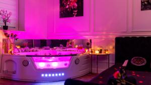 a hot tub with pink lights in a room at Vistula Boulevards Jacuzzi Apartment in Kraków