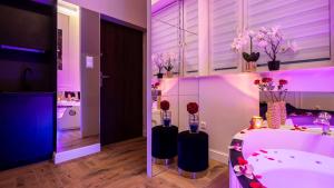 a bathroom with a tub with vases with flowers in it at Vistula Boulevards Jacuzzi Apartment in Kraków +4 photos