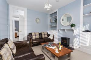 ein Wohnzimmer mit Sofas und einem Couchtisch in der Unterkunft Veronica Cottage in Swanage