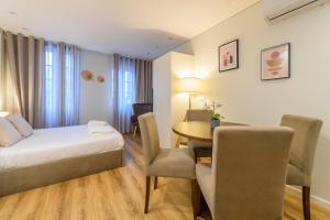 um quarto de hotel com uma cama, uma mesa e cadeiras em Braga Center Apartments - Dom Pedro V em Braga