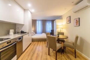 um quarto de hotel com uma cozinha, uma mesa e uma cama em Braga Center Apartments - Dom Pedro V em Braga
