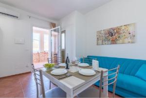 comedor con mesa y sofá azul en VILLA SESIFE Avola, en Avola
