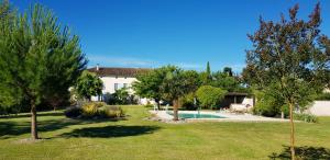 a house with a yard with a pool and trees at Villa de 7 chambres avec piscine privee jardin clos et wifi a Saint Palais du Ne 