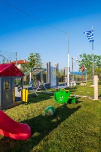 un parque con parque infantil con juegos rojos y verdes en Zikas Family's House, en Leptokarya