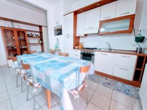 a kitchen with a table with chairs and a sink at Puzzle al Mare in Follonica
