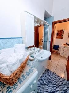 a bathroom with a sink and a basket of towels at Puzzle al Mare in Follonica