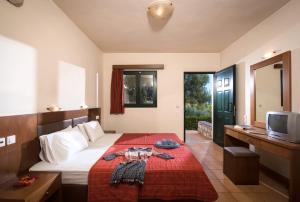 ein Schlafzimmer mit einem Bett mit einer roten Decke in der Unterkunft Dia Apartments in Hersonissos