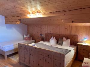 - une chambre avec 2 lits dans une pièce en bois dans l'établissement Au Alm, à Söll