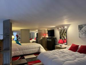 um quarto de hotel com duas camas e uma televisão em L'Ancre Rouge Deauville em Deauville
