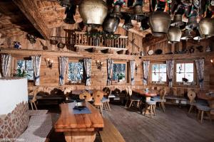 un restaurante con paredes de madera, mesas y sillas en Au Alm en Söll