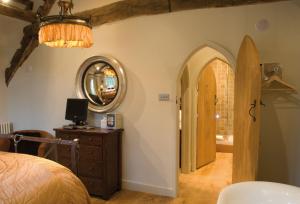 a bedroom with a bed and a mirror on the wall at The Gates in Castle Combe