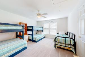 a bedroom with two bunk beds and a ceiling fan at Creekside --- 57 Tributary Lane in Millville