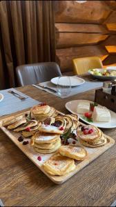 a tray of pancakes on a wooden table at Alpina Luxury Chalets in Banya