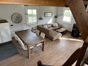 a living room with a couch and a table and a clock at Ferienhaus Sarcander in Glowe