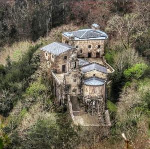 ein altes Haus an der Seite eines Hügels in der Unterkunft Adiva Praia Miño in Miño