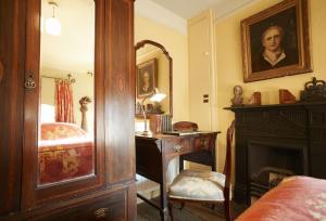 a bedroom with a desk and a bed and a mirror at Toll House in Nether Stowey