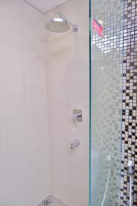 a shower with a glass door with an american flag at @Hom Semarang Simpang Lima in Semarang