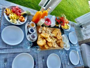 a picnic table with a tray of food and plates of food at Alpina Luxury Chalets in Banya