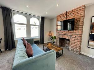 a living room with a blue couch and a fireplace at Stylish central apartment for 2 people free parking in Cardiff
