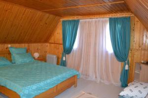 - une chambre avec un lit et une fenêtre avec des rideaux bleus dans l'établissement Cabana Timeea, à Ostrovu Corbului
